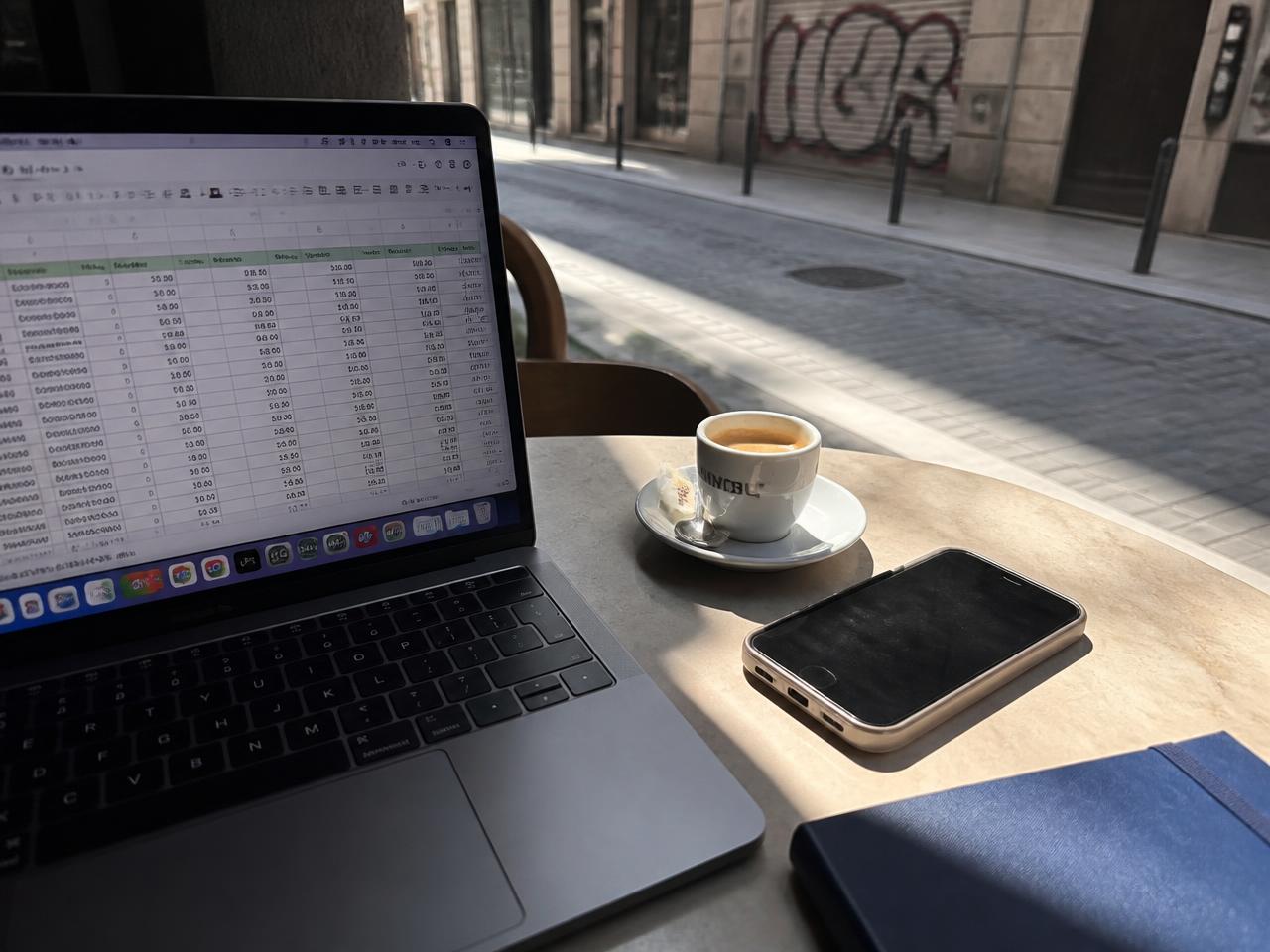 Morning cafe table in Barcelona with a laptop, espresso and phone